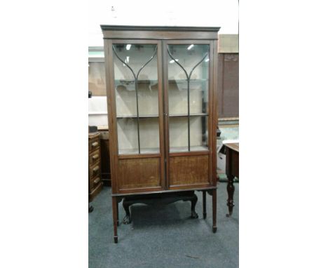 of rectangular form, the moulded&nbsp;top with plain frieze above a pair of astragal glazed panel doors opening to reveal a s