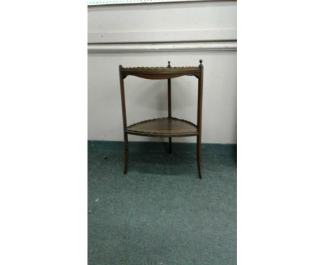 the low scalloped gallery rail surrounding a triangular inlaid top with a shaped frieze on slender square supports with splay