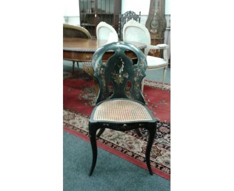the shaped back decorated with gilt, painted and mother of pearl flowers above a cane seat, all raised on splayed supports
