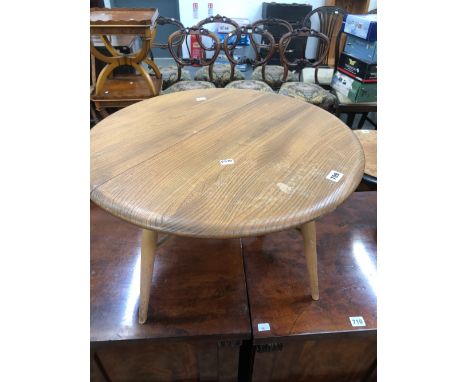 AN ERCOL TEAK FLAP TOP COFFEE TABLE, THE CIRCULAR TOP OPENING ON A SINGLE GATE.   Dia. 61 x H 35.5cms. 