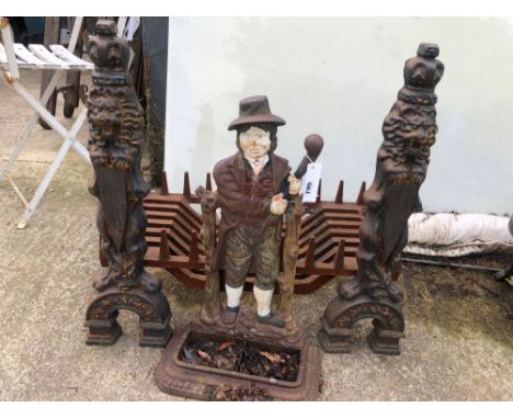 A CAST IRON FIRE GRATE WITH DOGS AND A PAINTED STICK STAND