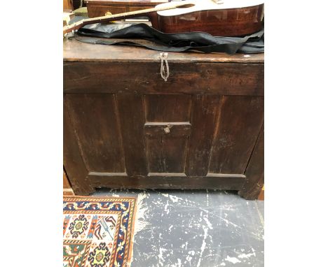 A LARGE OAK TRUNK OR COFFER, THE HINGED LID OVER AN INTERIOR HELD BY A CENTRAL IRON BAR.   W 120 x D 68.5 x H 94cms.