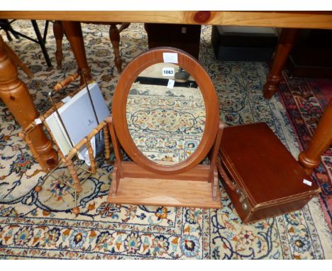 AN OVAL DRESSING TABLE MIRROR IN A PINE FRAME, A BAMBOO MAGAZINE RACK TOGETHER WITH A LEATHER SUIT CASE