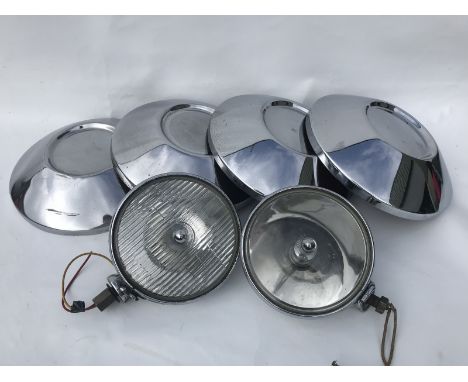 A pair of Lucas spotlamps and a set of four Vauxhall chrome plated hub caps. 