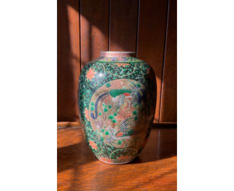 A Chinese ovoid vase, decorated with two  oval cartouches with two fanciful birds, the black ground with scrolling orange flo