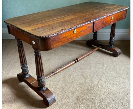 A William IV rosewood sofa table, rounded rectangular top, egg-and-dart border, the frieze with two drawers, fluted and lotus