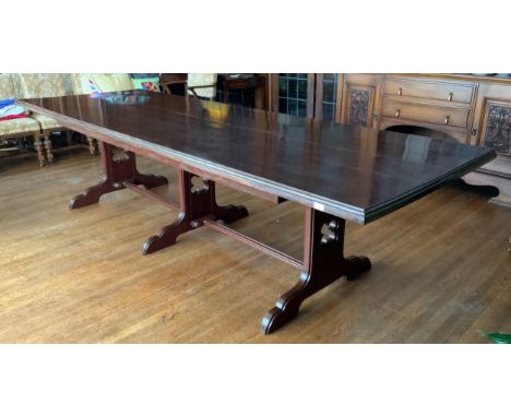 A large rectangular mahogany stained dining table, moulded edge, central stretcher with three fluted and pierced sledge legs,