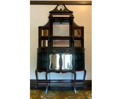 A Victorian ebonised chiffoniere, with blind fret swan neck pediment above two shelves and seven bevelled mirror panes, the p