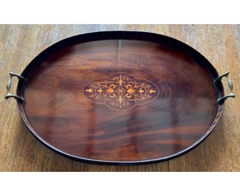 An early 20th century two handled mahogany tray, the field inlaid with in coloured woods with scrolls, banded gallery, 62cm w