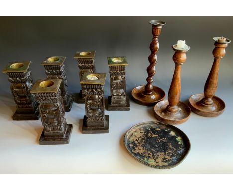A set of six  carved ebonised table candlesticks, 19cm high;  a pair of oak candlesticks, c.1930;  another, barley twist;  et