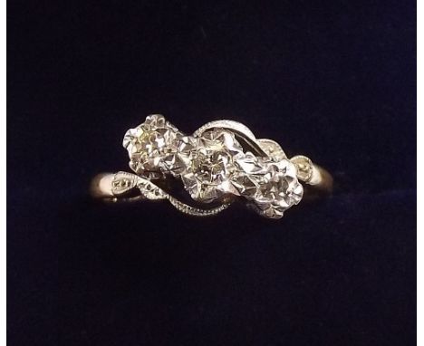 An 18 carat gold and platinum three stone illusion set crossover ring, size K and a half