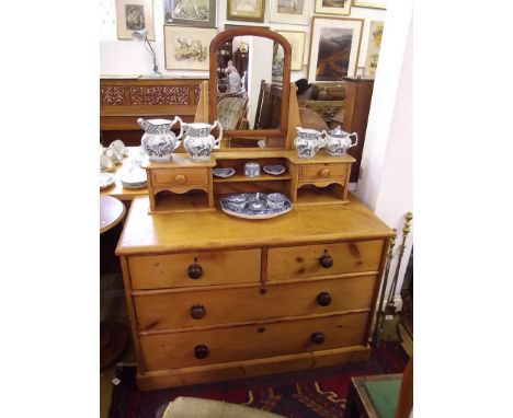 A Victorian pine dressing table with trinket drawers and mirror over two short and two long drawers