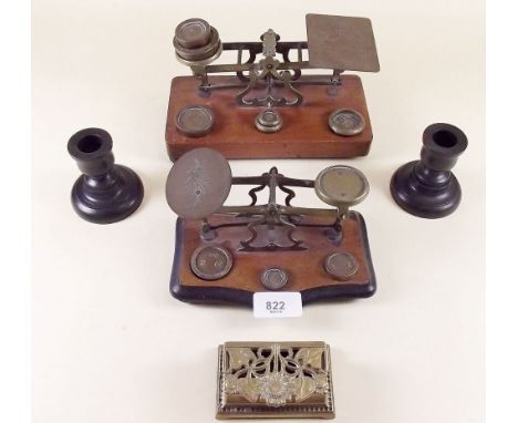 Two sets of Edwardian mahogany postal scales, a brass reproduction stamp box and two ebony candlesticks