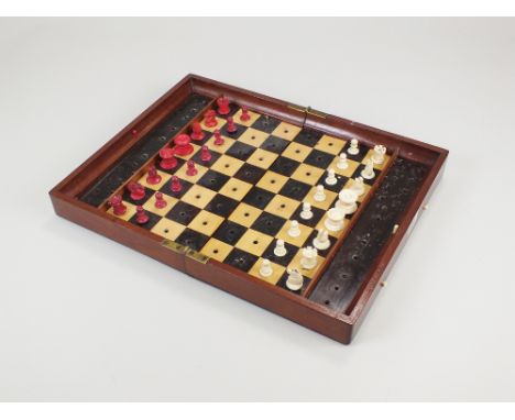 A Jacques and Son. folding mahogany travelling chess board and ivory and red stained ivory chess pieces, the box stamped Jacq