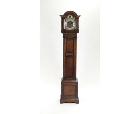 A 1920/30s Carolean style oak grandmother clock the arched hood enclosing an eight inch arched dial with silvered chapter rin