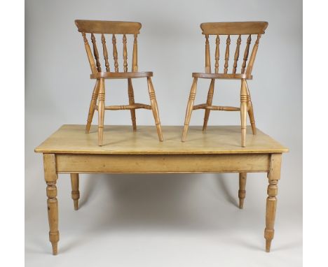 A pine kitchen table the rectangular top above a single end frieze drawer and raised on ring turned tapering legs, 160cm long