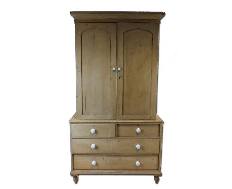 A Victorian pine kitchen cabinet on chest with later additions the indented arched panelled doors enclosing later shelving ab