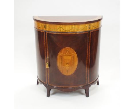 An Adam Revival mahogany and satinwood crossbanded and inlaid demi-lune side cabinet, with leaf and berry crossbanded top ove