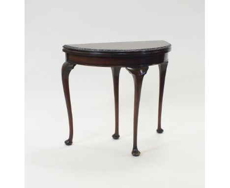 A Queen Anne style mahogany demi lune fold over top card table with acanthus moulded top edge and raised on four slender cabr