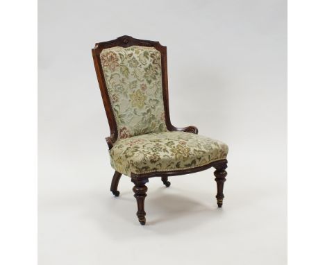 A Victorian walnut nursing or easy chair circa 1880 with later upholstered padded back and seat on ring turned and fluted fro