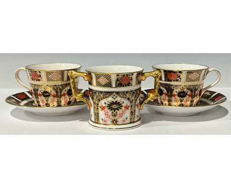 A Royal Crown Derby Imari 1128 pattern two handled loving cup, 8cm, first quality; a pair of 1128 pattern tea cups, seconds a