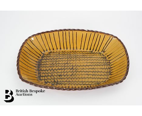 Slipware dish, ochre glaze with brown scale and trailing design, approx 28 x 19.5 cms.&nbsp;