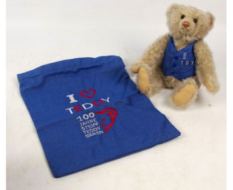 A Steiff Crystal teddy bear no. 660948, with numbered white and red tag to ear, with curly light beige mohair fur, with denim