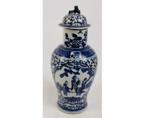 A large 19th century Chinese blue and white baluster vase decorated with figures in a landscape within a scrolling border wit