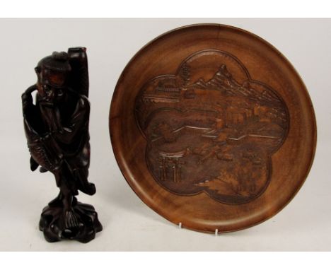 A Chinese carved rootwood figure of an elder with two fish, height 36cm (part missing), and a hardwood circular tray carved w