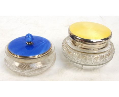 Two George V hallmarked silver topped and guilloche enamel decorated clear cut glass dressing table jars, the blue example wi