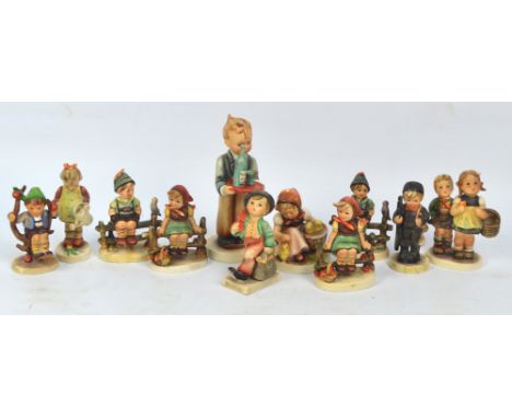 Eleven various Goebel/Hummel figures including two pairs of children seated on a fence and a waiter boy.