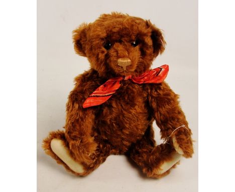 A boxed Steiff 1997 Raffles teddy bear, no. 652578, with numbered white and red tag to ear, with curly brown mohair fur and a