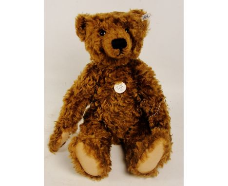 A boxed Steiff 1997 replica 1905 teddy bear, no. 404306, with numbered white and black tag to ear, with curly red brown mohai