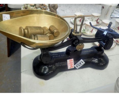 Pair of Libra black iron scales with two brass pans and four brass weights. Not available for in-house P&amp;P 