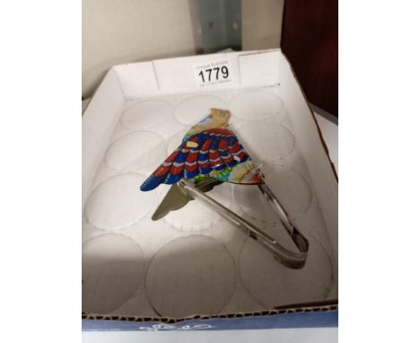 A vintage tin plate tweeting flapping squeeze tin toy bird