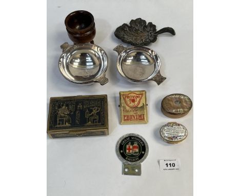 A box of sundries to include a Halcyon Days enamel box; two plated quaiches; an advertising letter clip and other objects