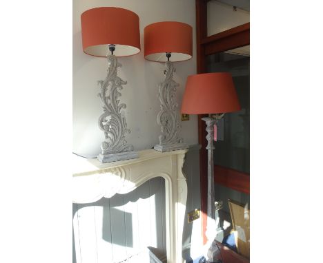 A PAIR OF CONTEMPORARY CARVED WOODEN TABLE LAMPS with grey distressed paint work and "terracotta" shades and a similar standa