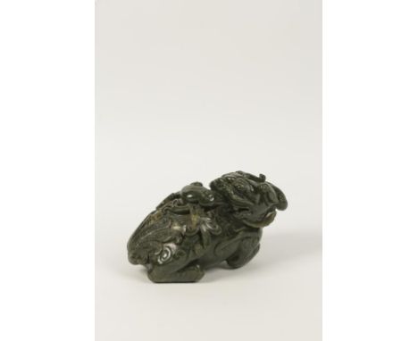 A CHINESE CARVED JADE/GREENSTONE FIGURE OF A FO DOG, 19th/20th century, 25cm long.