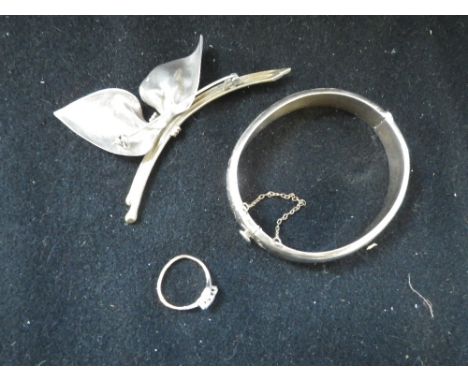 A THREE STONE DIAMOND RING on an 18ct yellow gold shank, ring size H, a silver bangle and a brooch (3)