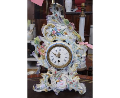 A 19TH CENTURY CONTINENTAL CERAMIC ROCOCCO DESIGN MANTEL CLOCK with white painted enamel dial with Roman and Arabic numerals 