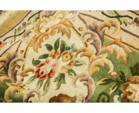 LARGE CHINESE CARPET
with central crest and stylised floral and scrolling motifs in predominantly blue, purple, burnt orange,