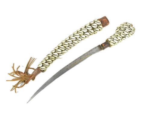 An early 20th Century North African (Algeria) Flyssa dagger with a clad leather hilt and scabbard covered with rows of cowrie