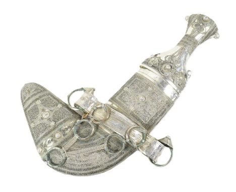 An early 20th Century Middle Eastern / Omani Khanjar / Jambiya dagger. Waisted grip with intricate white metal filigree decor