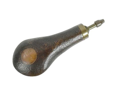 A vintage hand beaten copper musket powder flask with ' E W ' initials. The spout mechanism pulls down to release the powder.
