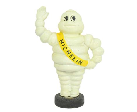 A vintage cast iron Michelin Tyre Man Bibendum money box figurine. Mounted onto a tyre shaped base. Measures approx 22cm.