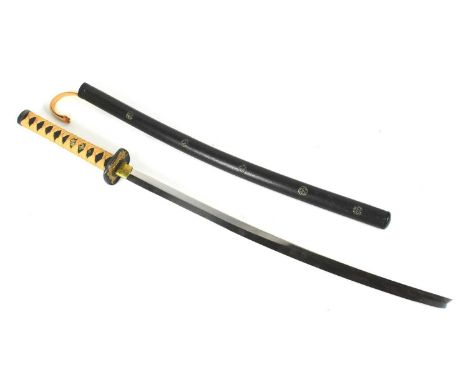 A vintage Japanese Samurai Katana sword. Black faux rayskin grip with rope binding and a square tsuba depicting a gold samura