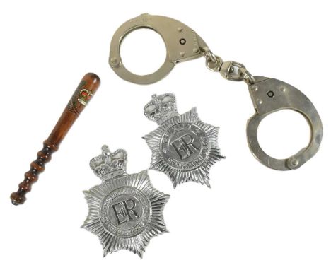 A collection of assorted British Police items comprising Gwent and Nottinghamshire Constabulary hat badges, a small display t