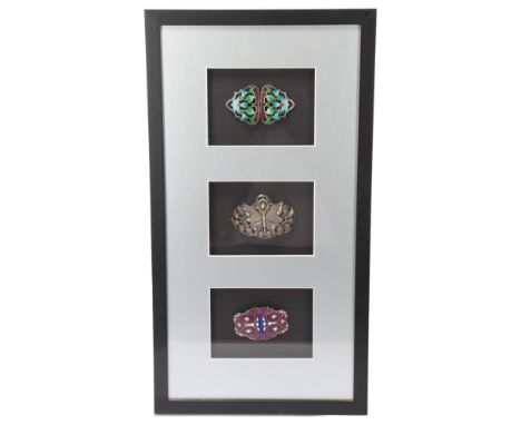 3 Art Nouveau enamelled and gem set buckles, mounted in good quality modern frame, overall frame dimensions 56cm x 30cmGood c