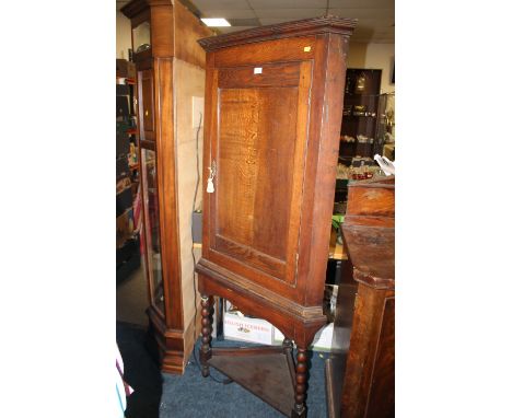 AN OAK CORNER CUPBOARD ON A BOBBIN TURNED BASE