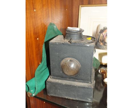 A VINTAGE RAILWAY LAMP STAMPED LMS TOGETHER WITH A VINTAGE GREEN FLAG 